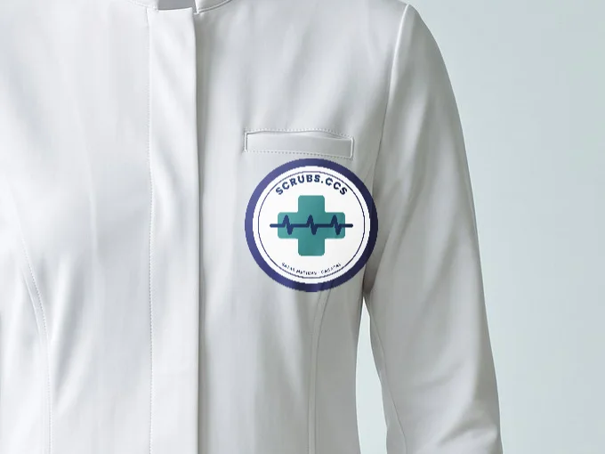 Logo a color aplicado en vinil textil sobre el pecho de la bata blanca, hecho con el probador